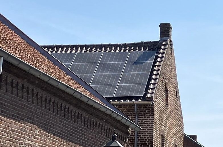 een dak van een monumentaal pand bedekt met zonnepanelen